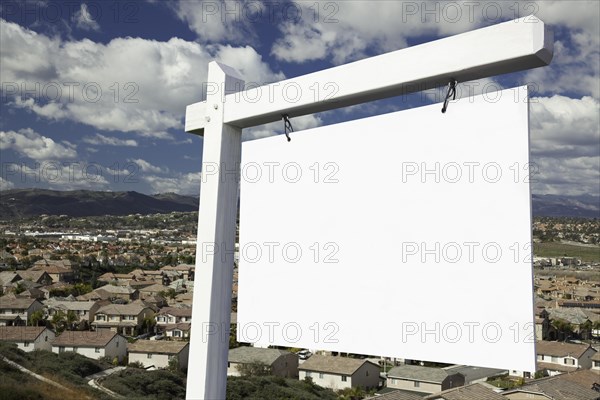 Blank real estate sign with elevated housing community view