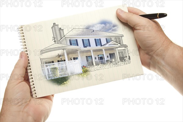 Male hands holding pen and pad of paper with house drawing isolated on a white background