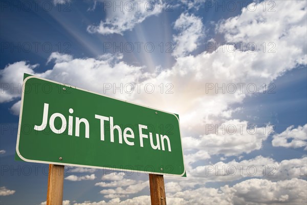 Join the fun green road sign with dramatic clouds and sky