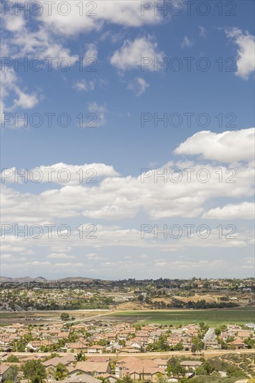 Elevated view of new contemporary suburban neighborhood and majestic clouds