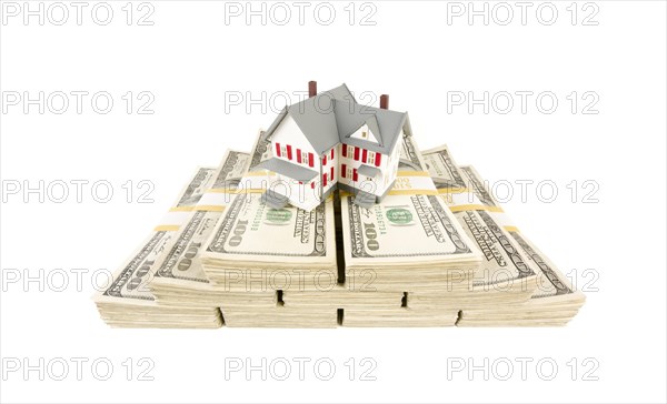 Small house on stacks of hundred dollar bills isolated on a white background