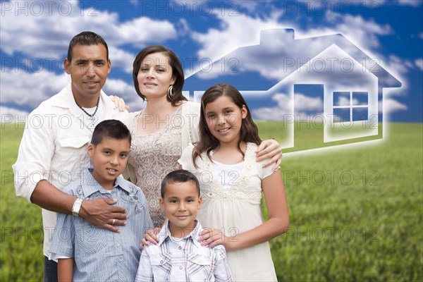 Happy hispanic family standing in grass field with ghosted house behind