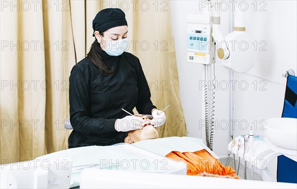 Woman dentist with patient lying down