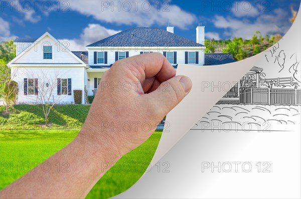Male hand turning page of custom home photograph to drawing underneath