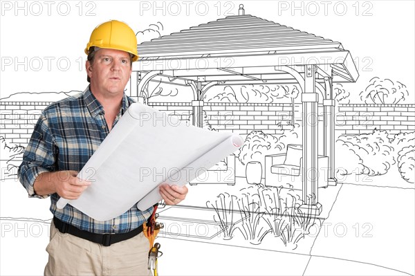 Male contractor with house plans wearing hard hat in front of custom pergola patio covering drawing