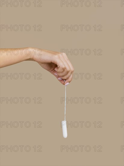 hand holding tampon front view