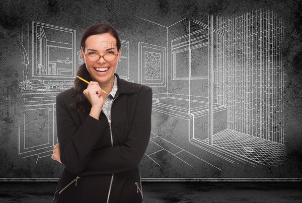 Young adult woman with pencil in front of bathroom design drawing on wall