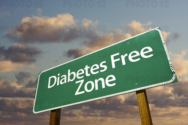 Diabetes free zone green road sign in front of dramatic clouds and sky