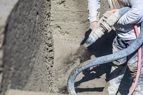 Pool construction worker shooting concrete