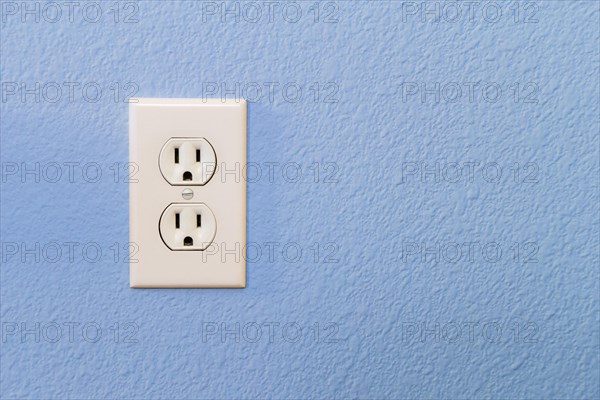 Electrical sockets in colorful blue wall of house