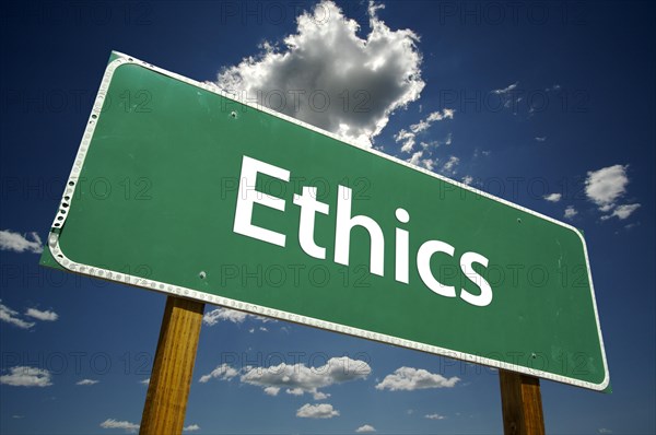 Ethics green road sign with dramatic blue sky and clouds