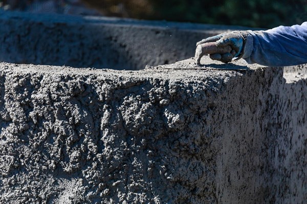 Pool construction worker working with A smoothing trowel on wet concrete