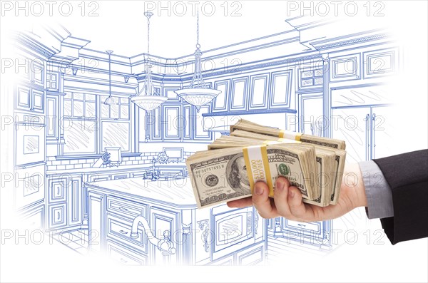 Hand holding stacks of money over custom kitchen design drawing