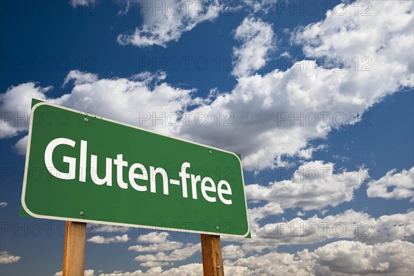 Gluten-free green road sign over dramatic blue sky and clouds