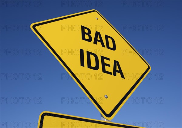 Yellow bad idea road sign against A deep blue sky with clipping path