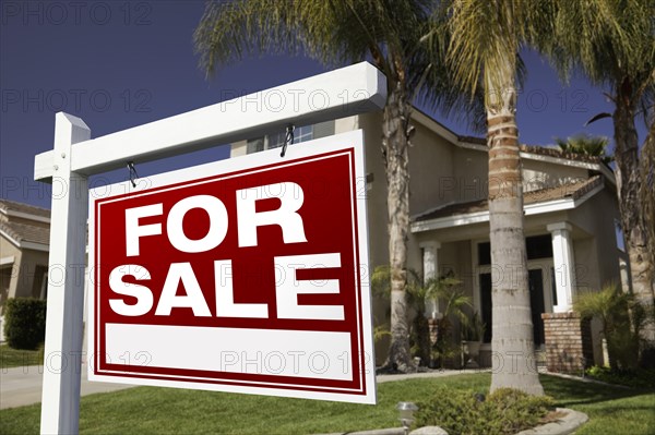 For sale real estate sign in front of house