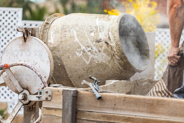 Construciton worker mixing cement at construction site