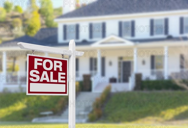 Home for sale real estate sign in front of beautiful new house