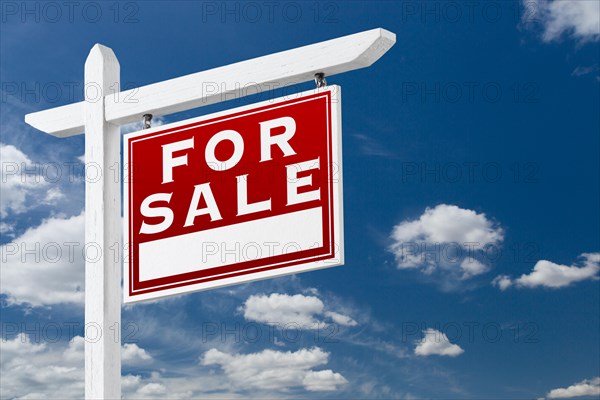 Right facing for sale real estate sign over blue sky and clouds with room for your text