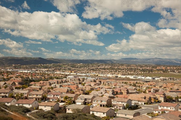 Elevated view of new contemporary suburban neighborhood and majestic clouds