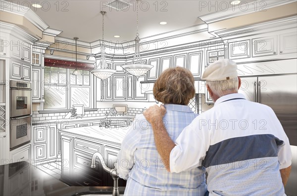 Senior couple looking over custom kitchen design drawing and photo combination
