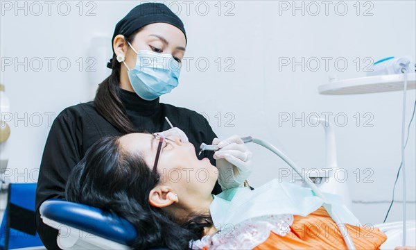 A dentist cleaning a patient's mouth