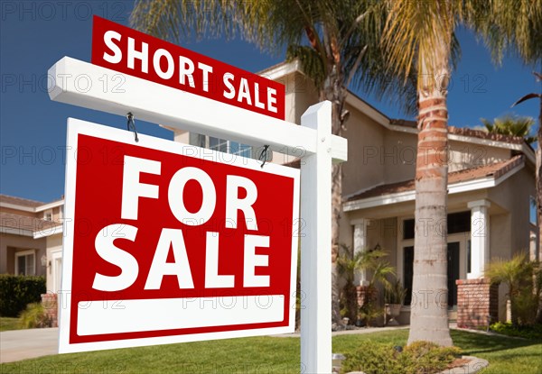Short sale home for sale real estate sign and house