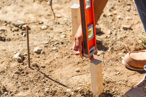 Worker using level at construction site