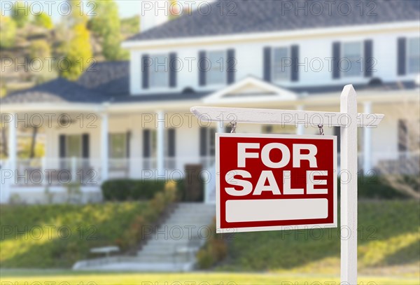 Home for sale real estate sign in front of beautiful new house