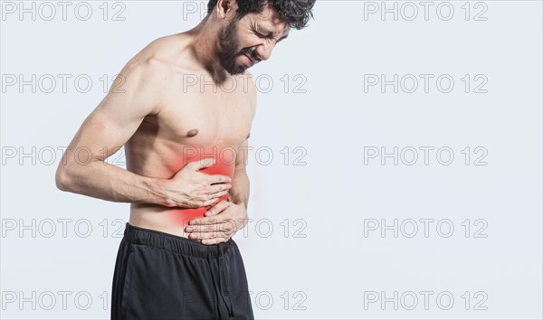 Shirtless man with stomach ache