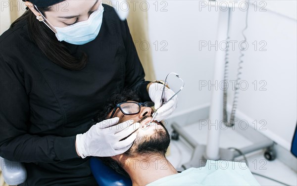 Dentist checking braces to patient