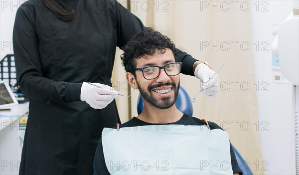 Dentist examining mouth to smiling patient