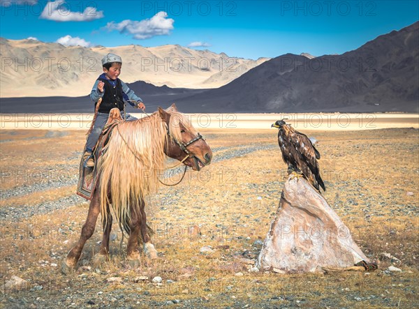 A boy trains his young eagle for hunting. After 3 months the eagle is ready for fox hunting