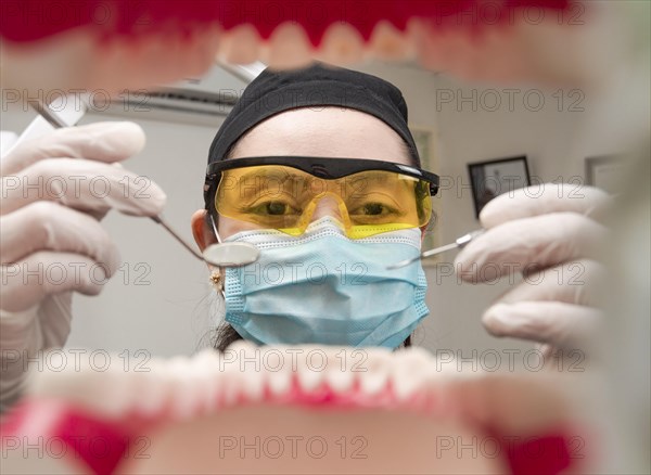 A dentist cleaning a mouth inside view