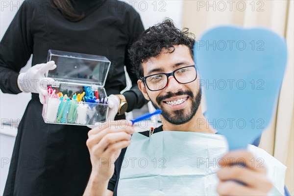 Dentist with patient choosing metal braces