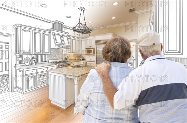 Senior couple looking over custom kitchen design drawing and photo combination