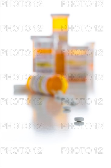 Non-Proprietary medicine prescription bottles and spilled pills isolated on a white background