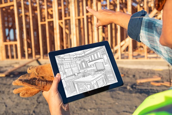 Female construction worker reviewing kitchen drawing on computer pad at construction site