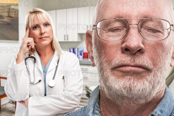 Empathetic doctor standing behind troubled senior adult man in office