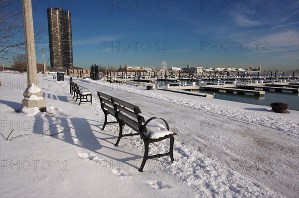 Empty snowy bench in chicago after winter snow along lake shore drive