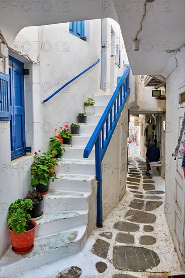 Picturesque scenic narrow Greek streets with traditional whitewashed houses with blue doors windows of Mykonos town in famous tourist attraction Mykonos island