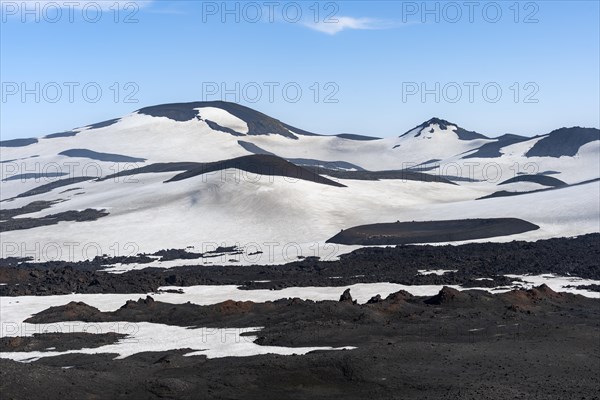 Barren hilly volcanic landscape of snow and lava fields