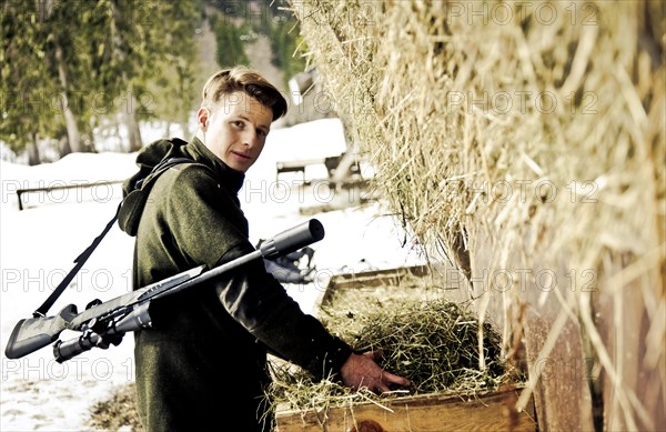 Hunter filling trough with hay