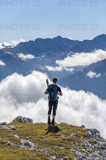 Hiker with climbing helmet on a steep rocky ridge