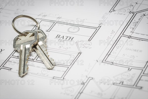 Set of new house keys resting on custom house plans