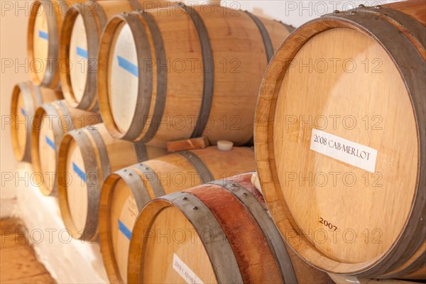 Several various wine barrels age inside cellar