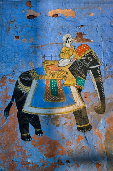 Mural of Maharajah on elephant on blue house wall in Jodhpur also known as Blue City due to the vivid blue-painted Brahmin houses. Johdpur