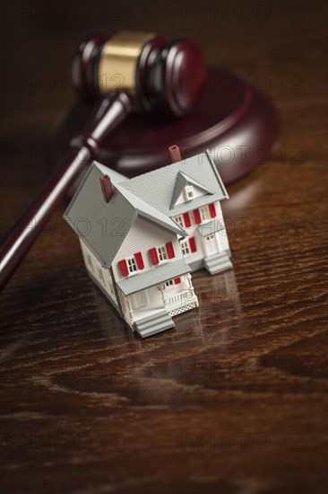 Gavel and small model house on wooden table
