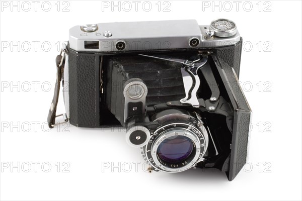 Old folding camera isolated on white background