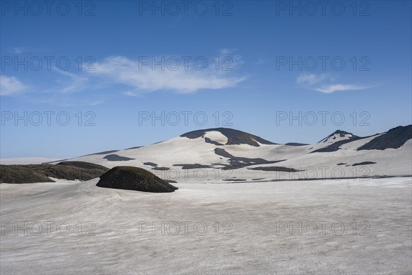 Barren hilly volcanic landscape of snow and lava fields
